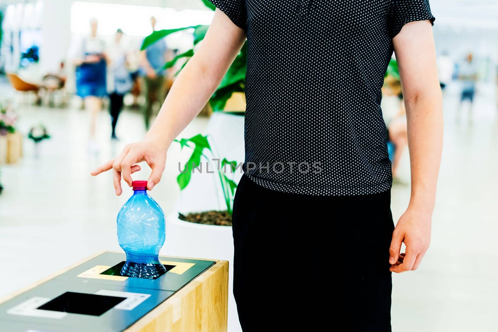 Selective focus close up hand throwing empty plastic bottle in the recycling garbage trash or bin