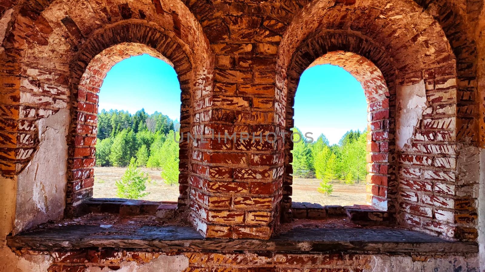 Small narrow windows on old, ancient, cracked stone shabby brick wall of red brick in church. Architecture background, interior, location