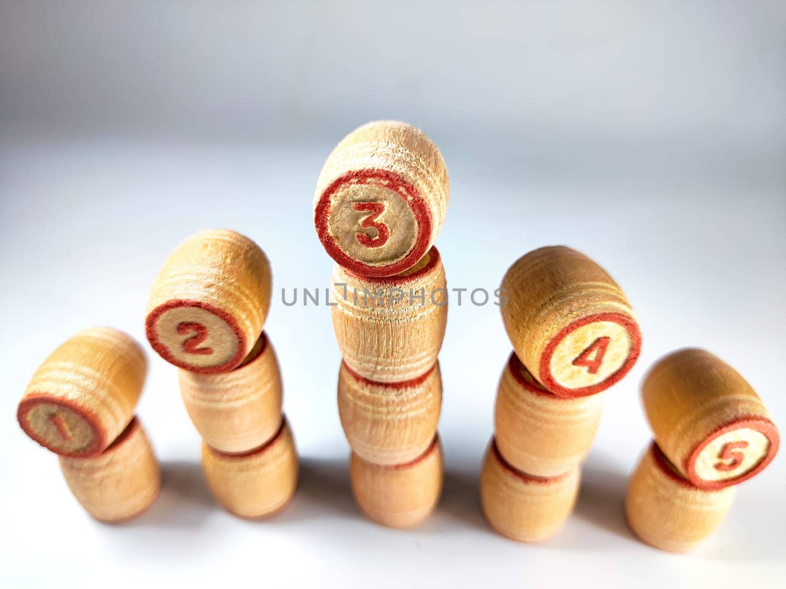 Small wooden barrels with numbers built in columns. The concept of forward movement when achieving the goal and a decrease in performance after takeoff. The undulating movement of evolution by keleny