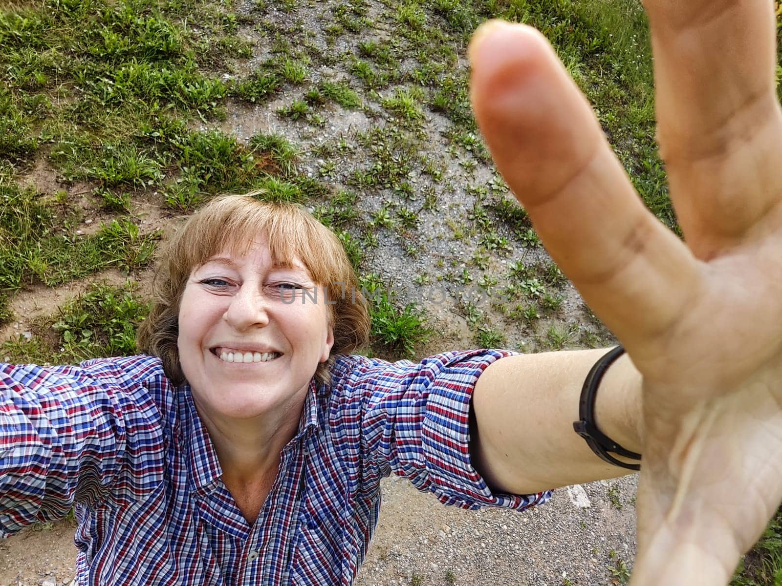 Funny adult girl posing in nature. A middle-aged woman takes a selfie in the landscape. City tourist on vacation on a picnic by keleny