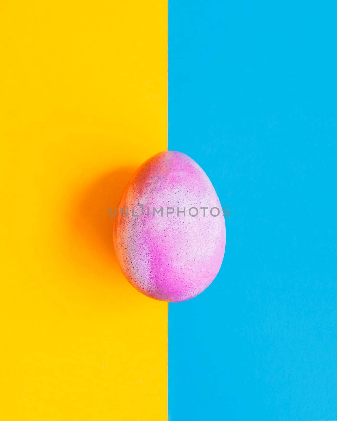 Cosmic galactic Easter egg on blue and yellow pastel background