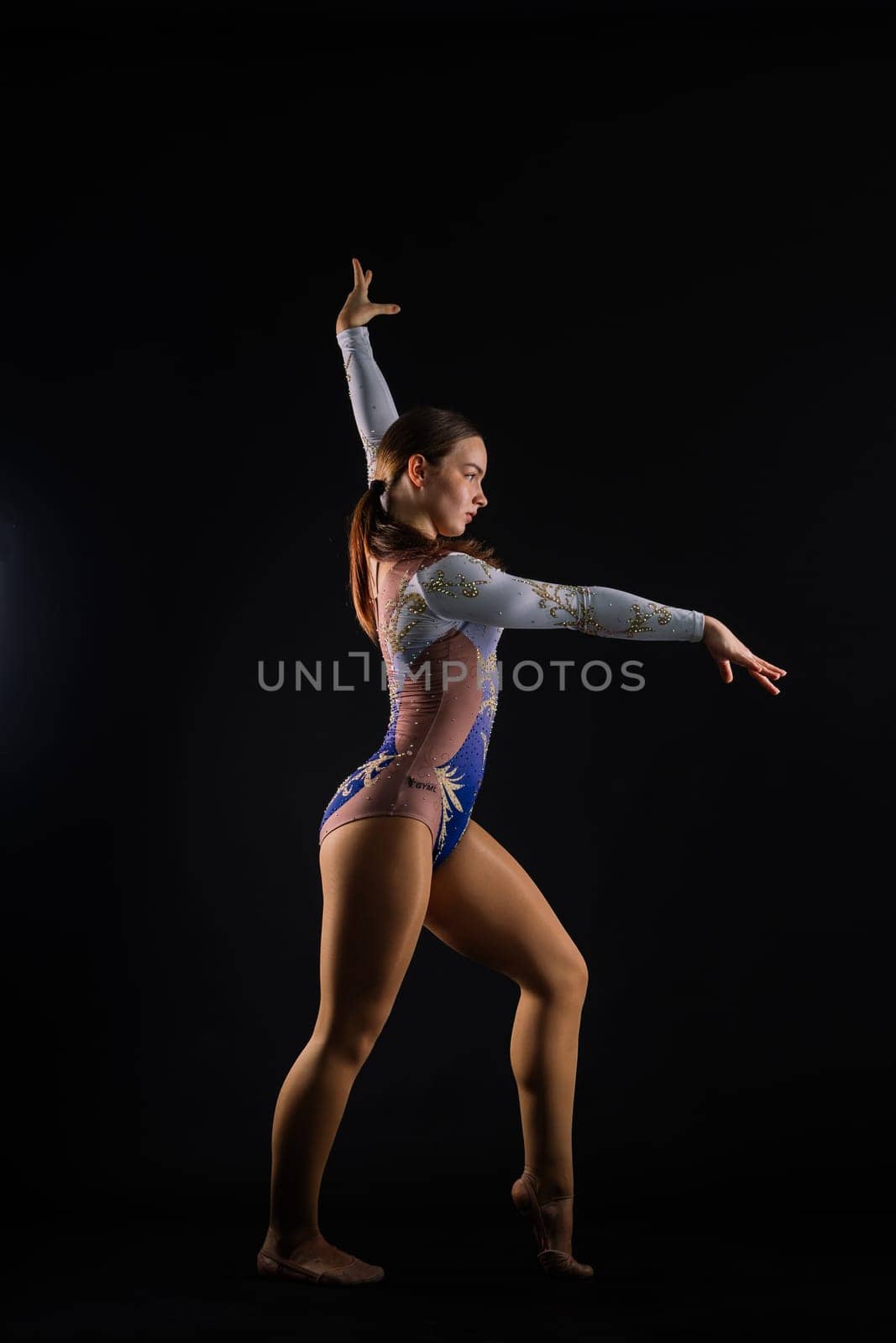 Beautiful plump brown-haired woman in black bodysuit in a studio. Caucasian dancehall dancer posing by Zelenin