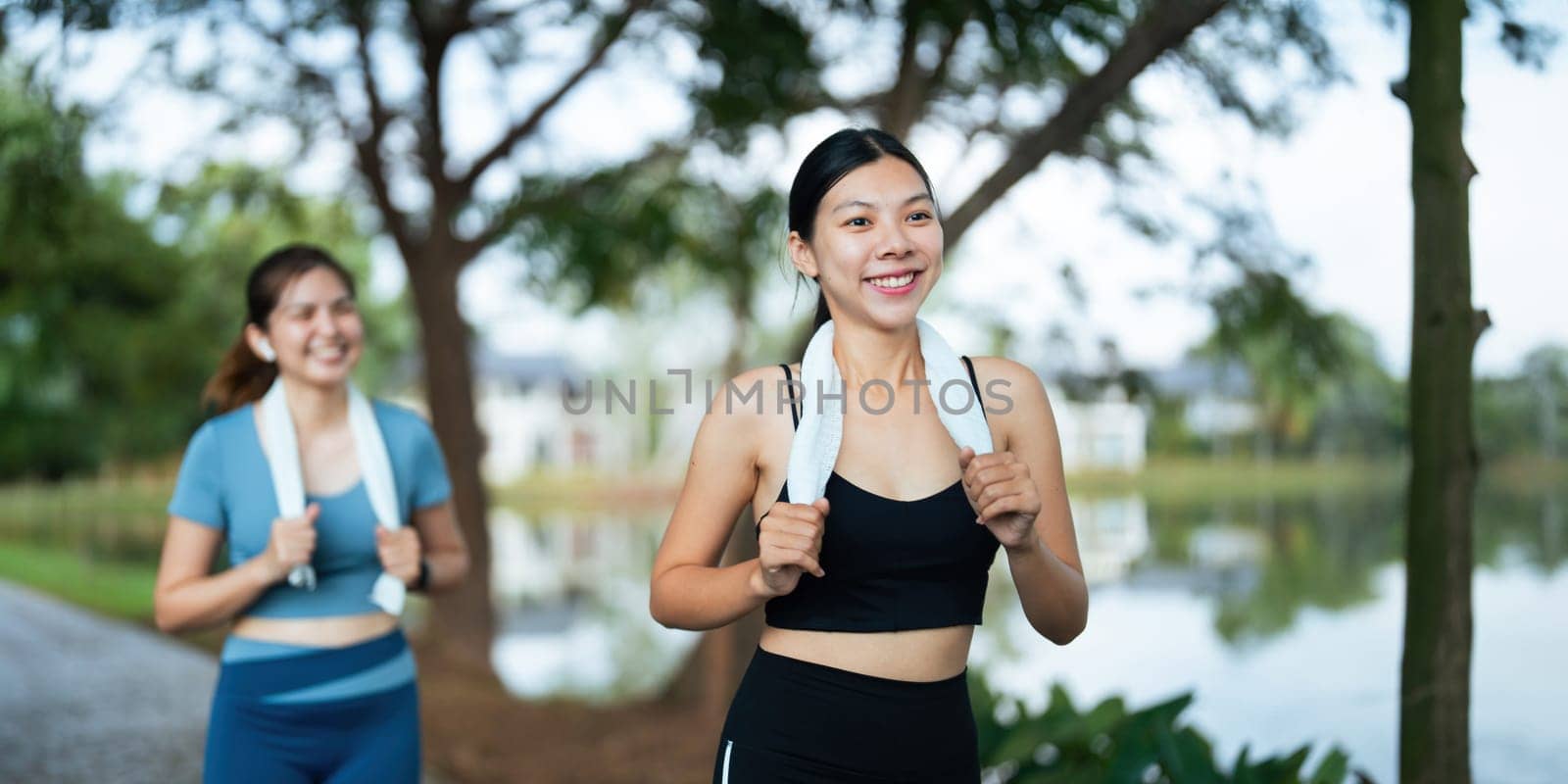 Jogging woman running in park on beautiful day off. Sport fitness model of asian ethnicity training outdoor for marathon by nateemee