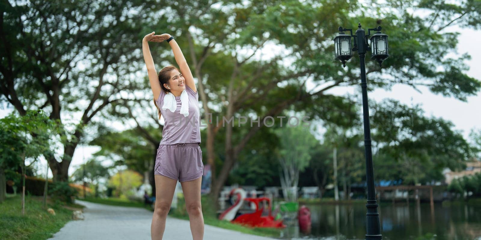 Young woman stretch during stretching exercise outdoors in the park.