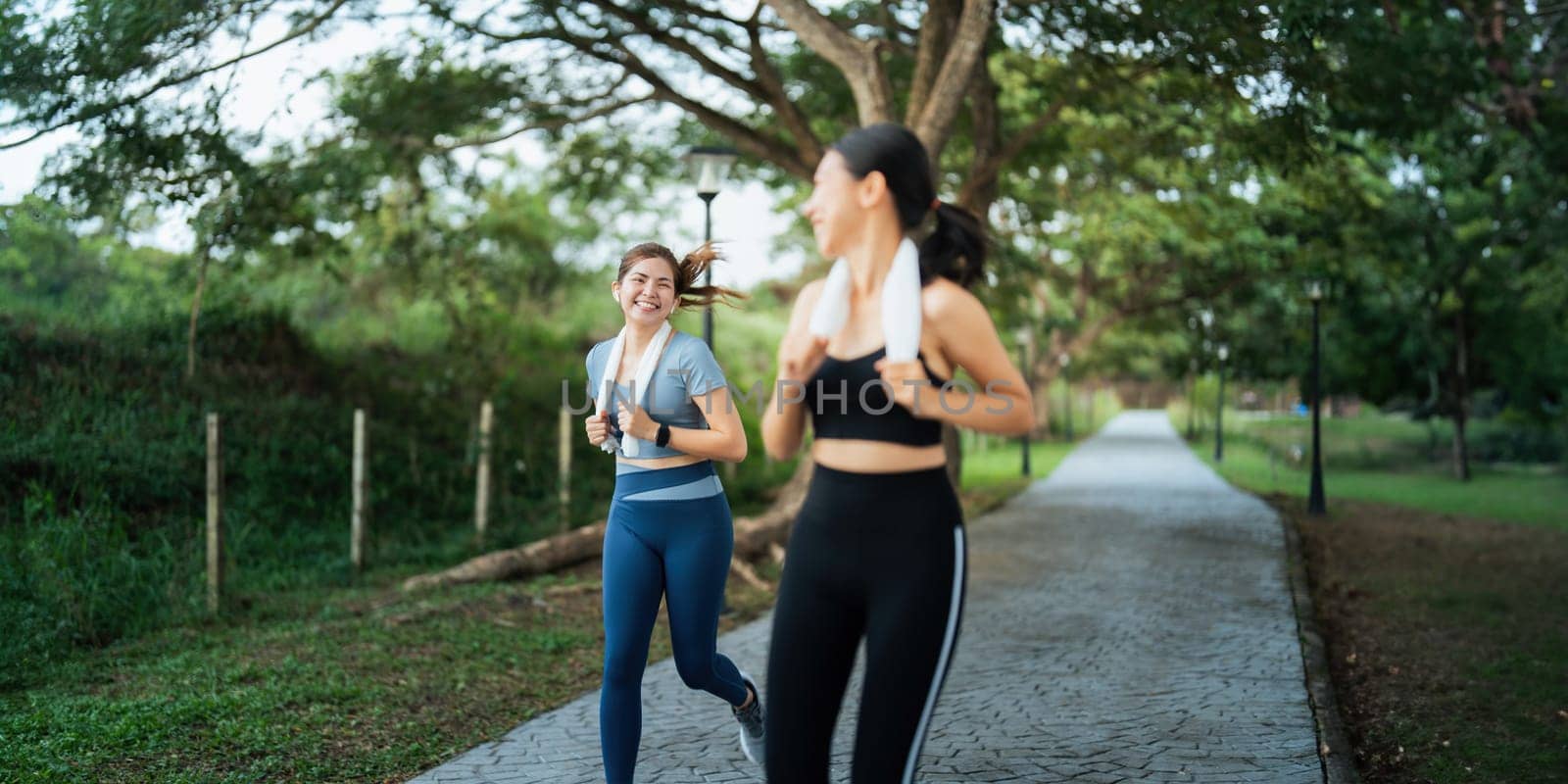 Healthy and active lifestyle, sport concept. Attractive ecstatic young sportswoman, smiling joyfully as jogging, sprinter run in park by nateemee