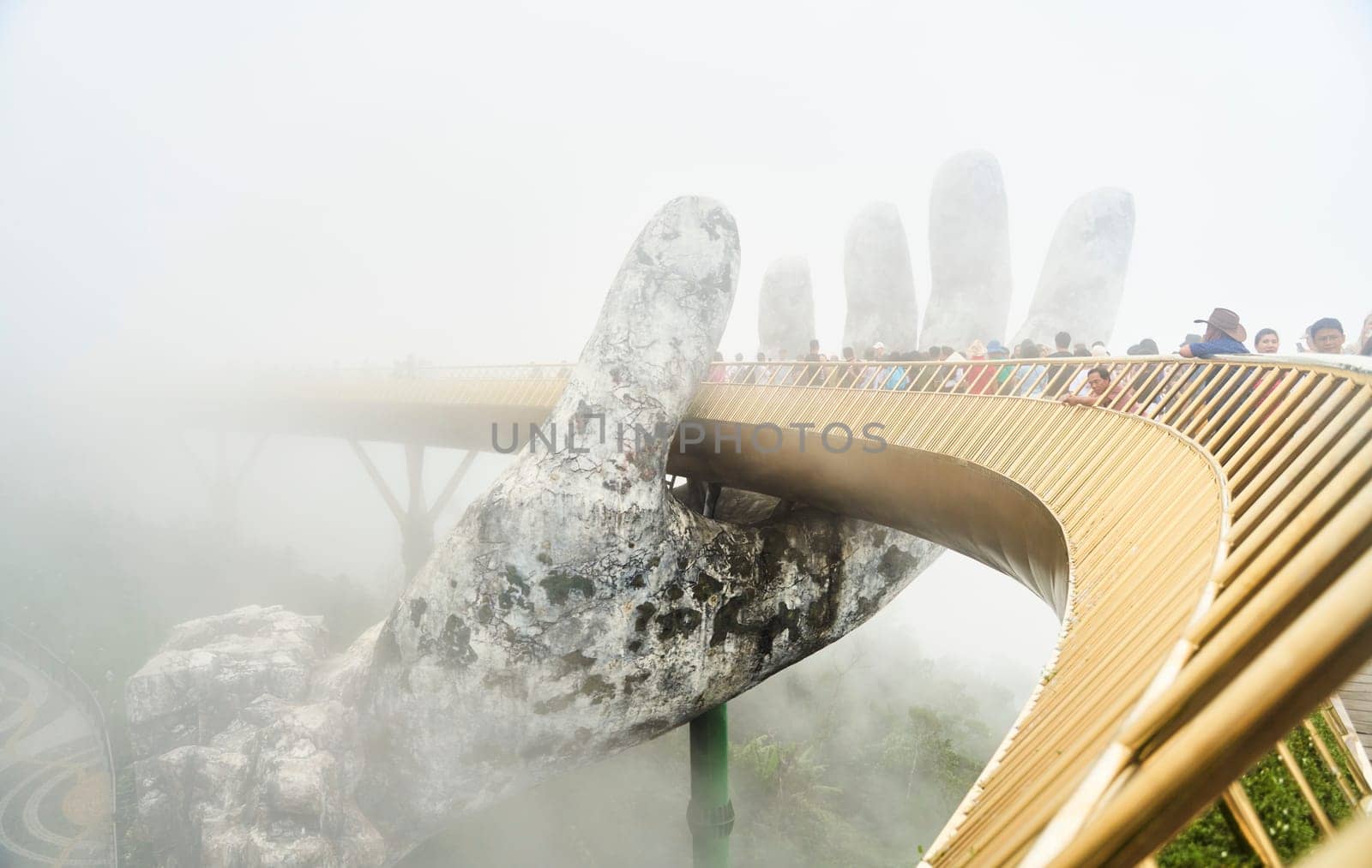 Danang, Vietnam - June 27, 2023: The Golden Bridge is lifted by two giant hands in the tourist resort on Ba Na Hill by driver-s