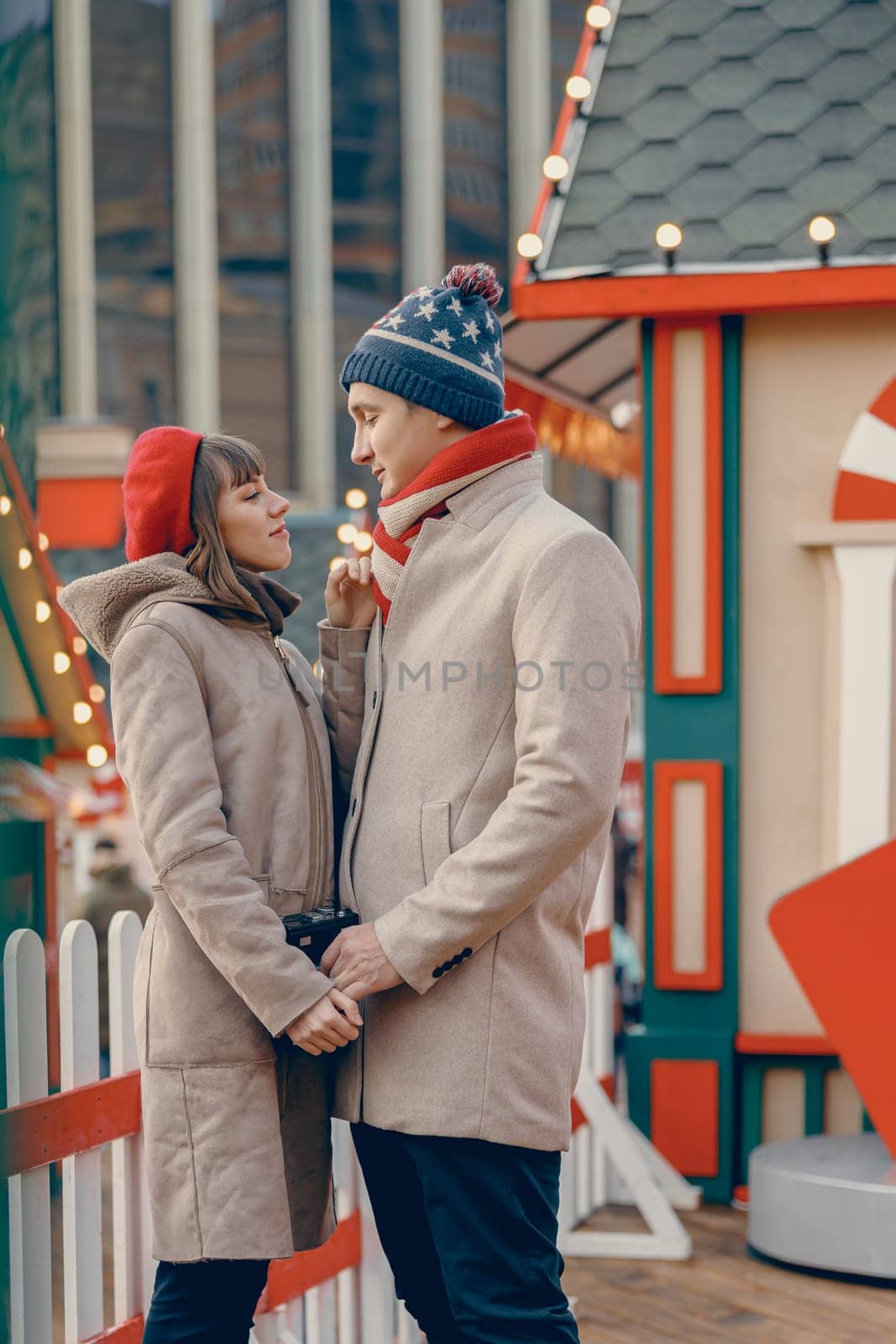 In a holiday setting, a couple shares a tender moment, connecting deeply amidst the lively charm of a Christmas market