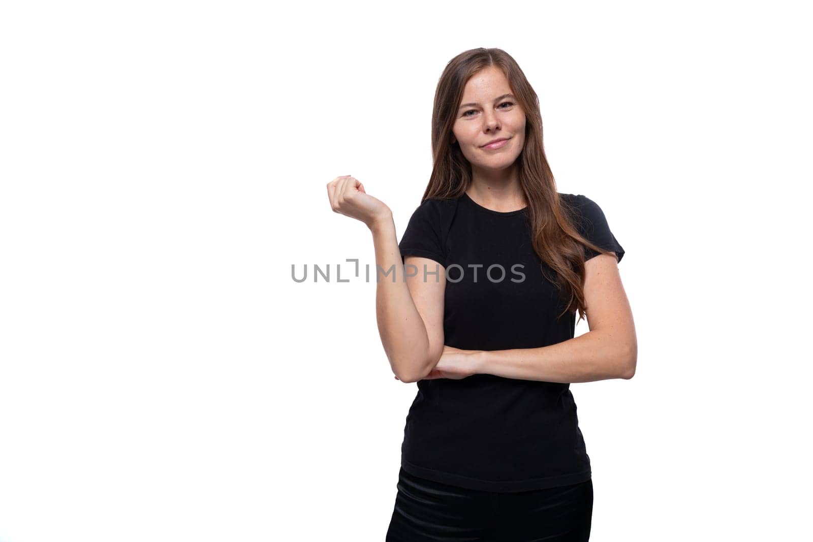Dreamy young woman with straight hair wearing a black T-shirt on a white background.