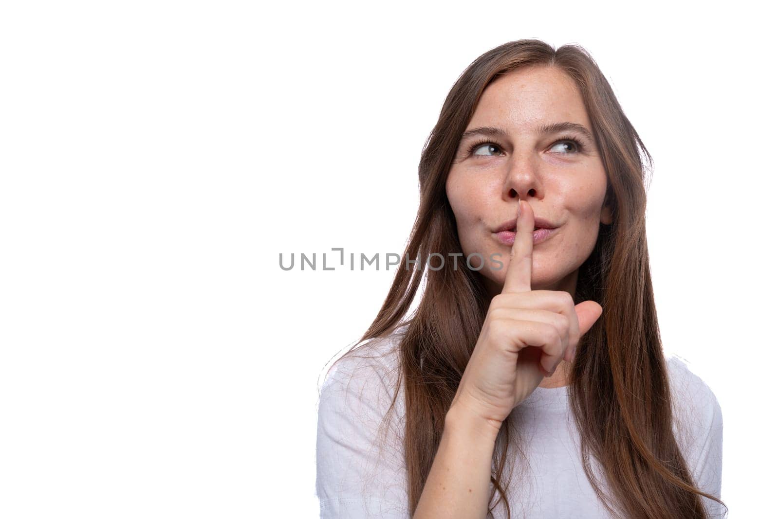 Young woman keeping a secret and covering her mouth with her finger.