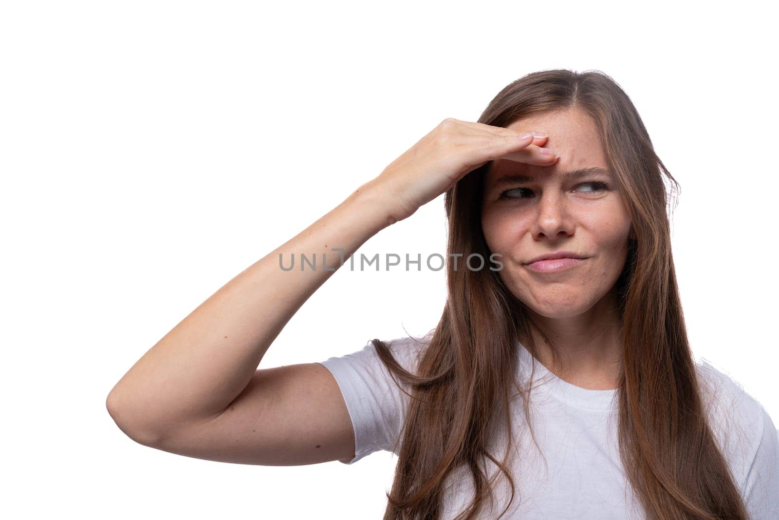 A young woman of European appearance is puzzled and holds her head by TRMK