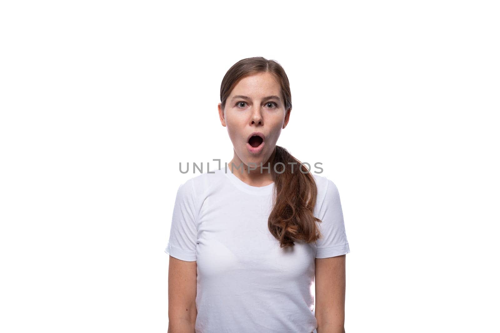 Young woman looks at the camera in surprise with her mouth open.