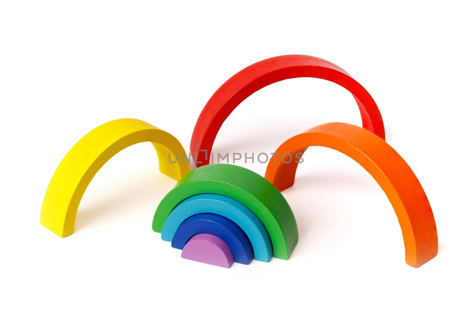 Kid's wooden educational Montessori puzzle toy set in the form of a colorful rainbow isolated on white background.