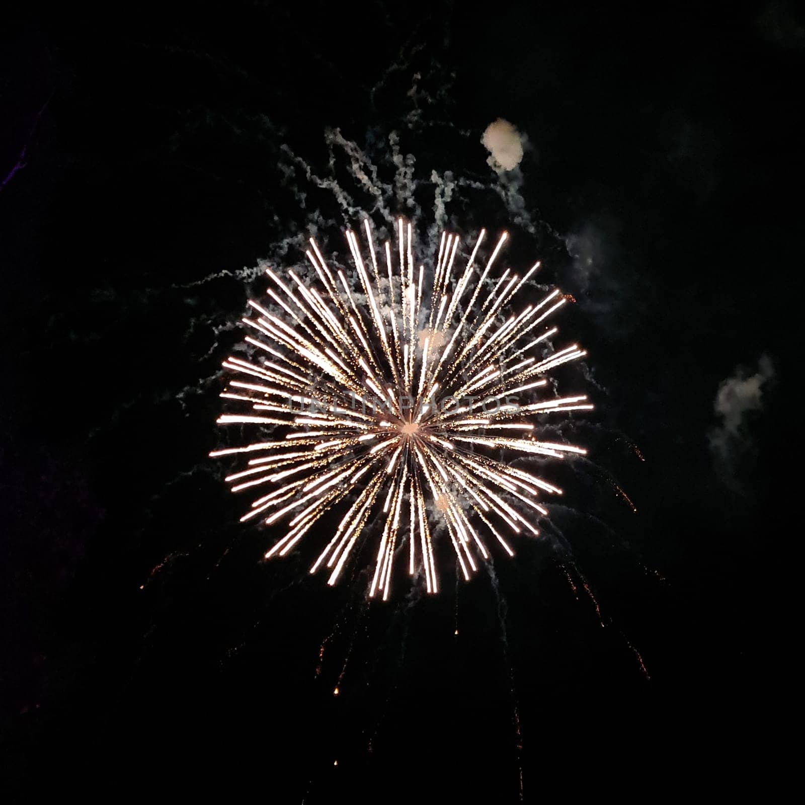 Photo of real fireworks in circle shape with smoke paths on black sky background for overlay blending mode.