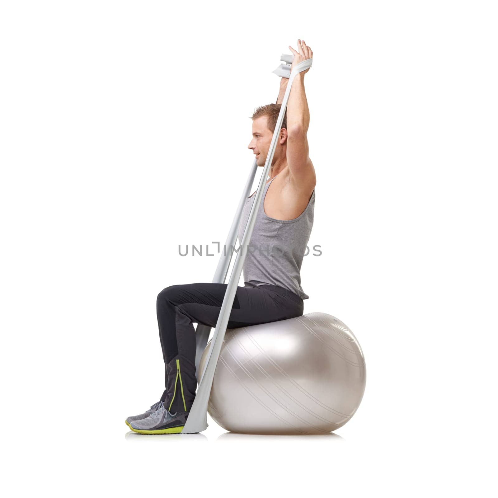 Yoga ball, resistance band and man doing exercise in studio for health, wellness and bodycare. Sport, fitness and young male person from Australia with arms workout or training by white background