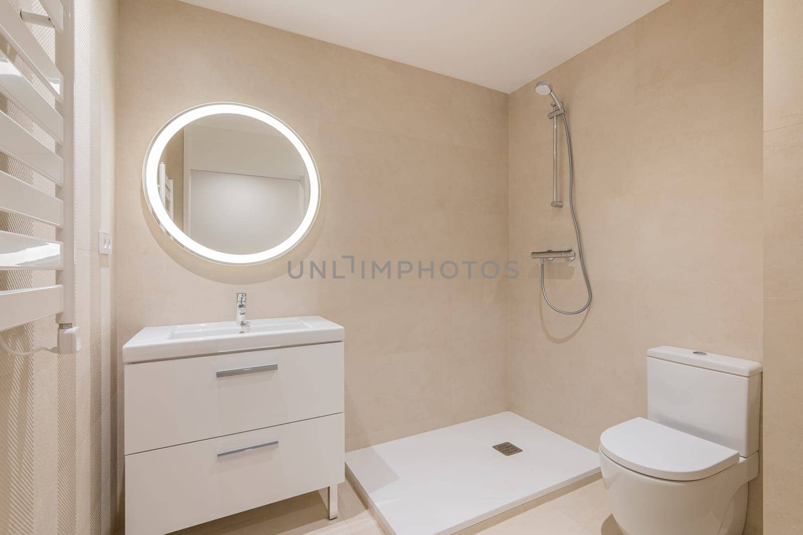 Bathroom with toilet bowl, shower area and washbasin with drawer and mirror above. Minimalistic medium-sized bathroom with essentials
