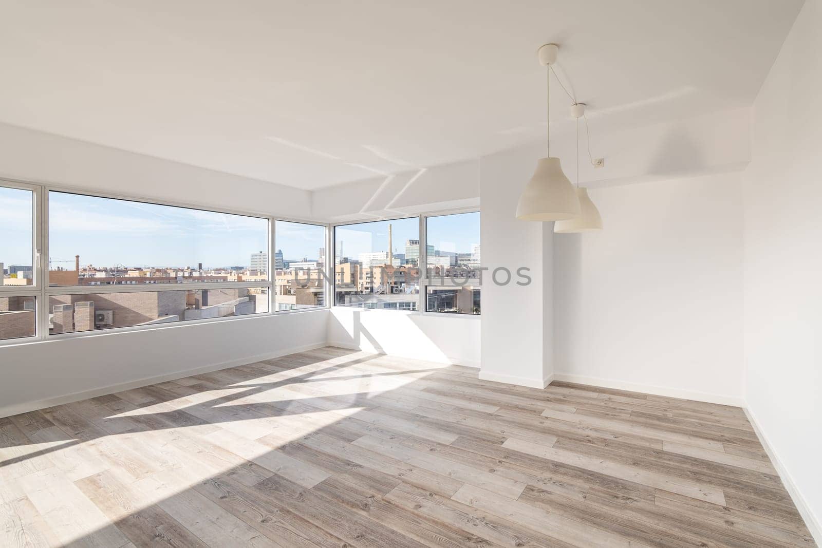 Spacious empty room with windows overlooking Barcelona. Designer apartment after renovation without furniture with wonderful view of city