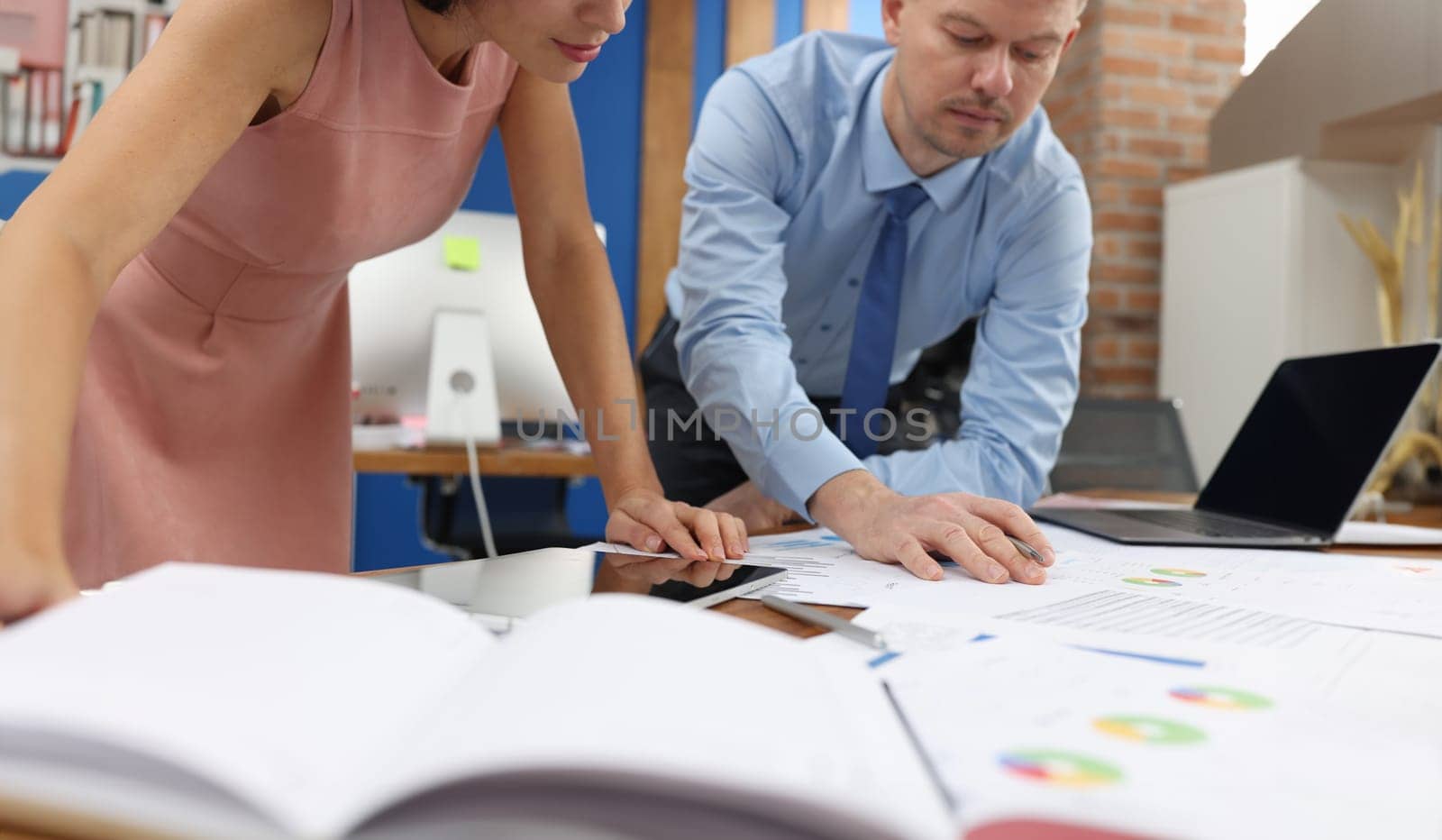 Business man and woman studying documents at table in office closeup. Business strategy concept