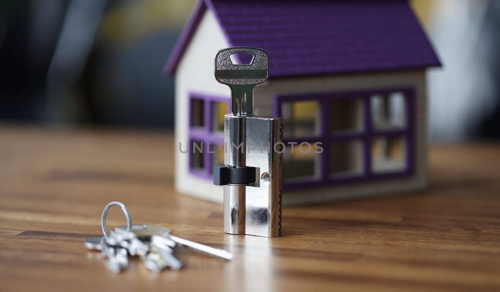Keyhole and keys lying on background of toy wooden house. Installation of door locks concept