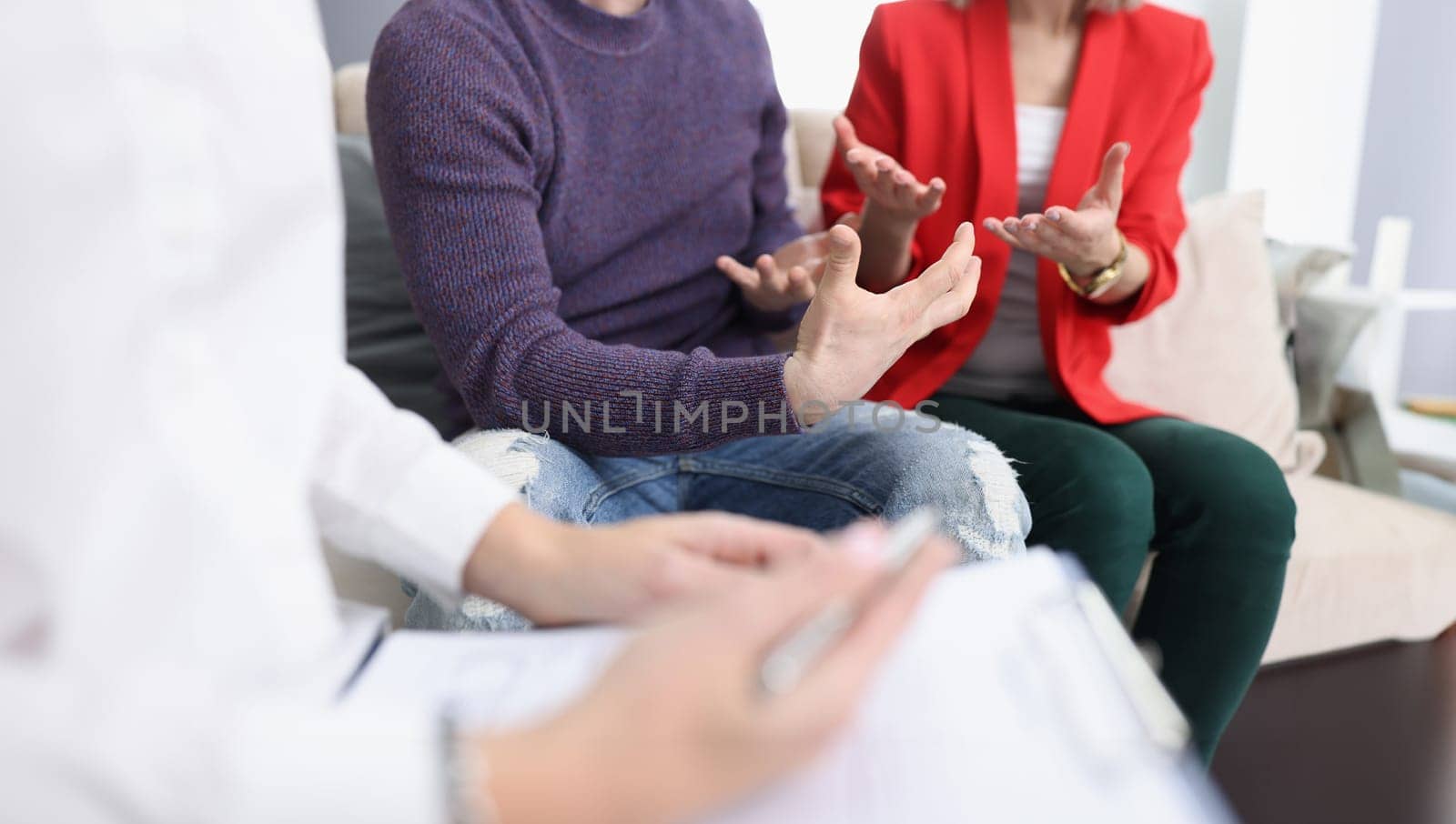 Young couple communicating with psychologist in office closeup. Family psychologist concept
