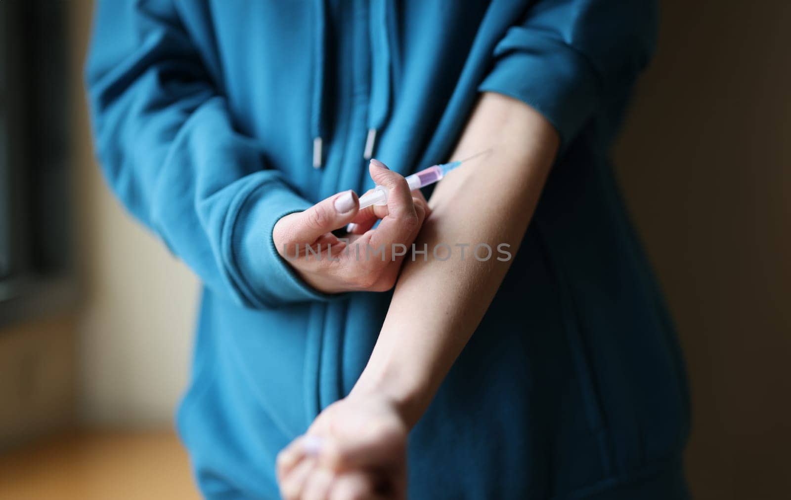 Woman making herself intravenous drug injection closeup. Heroin addiction concept