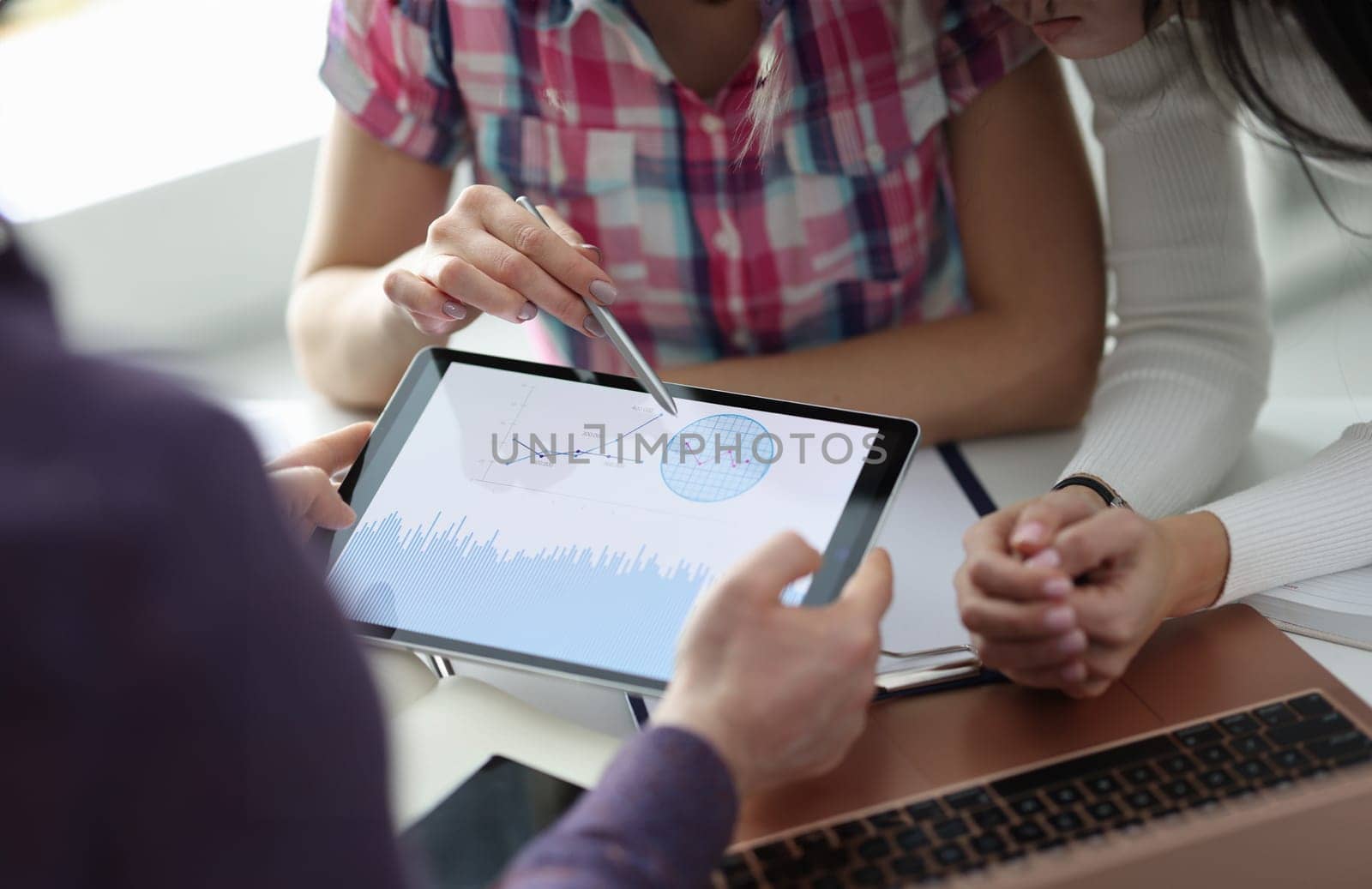 Group of people discussing graph on digital tablet closeup. Profit growth concept