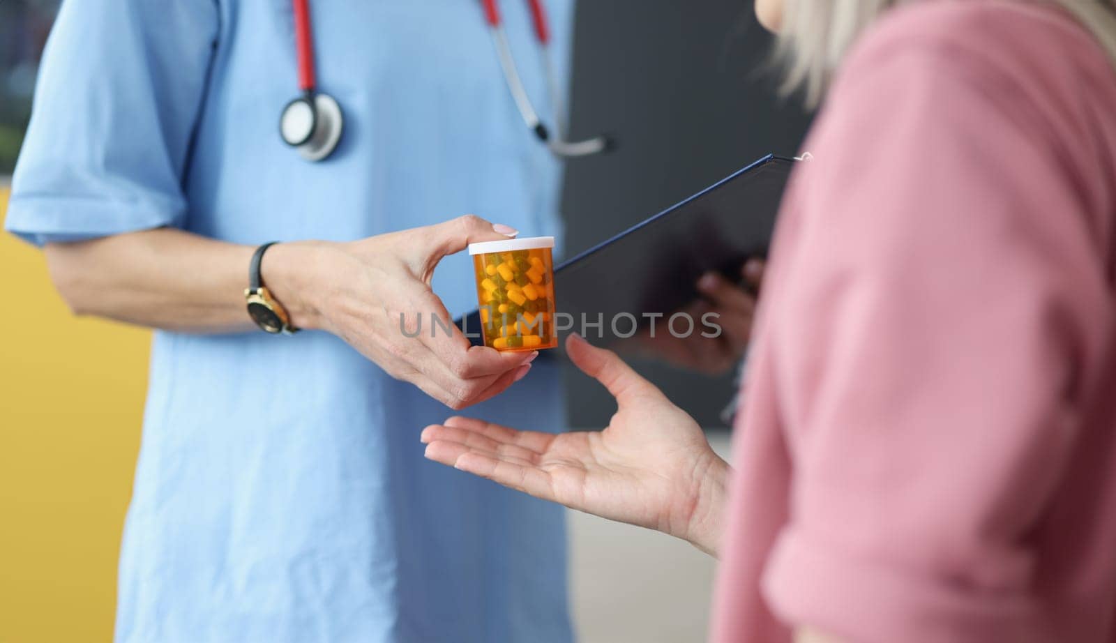 Doctor giving jar of pills to patient closeup. Pharmaceutical business concept