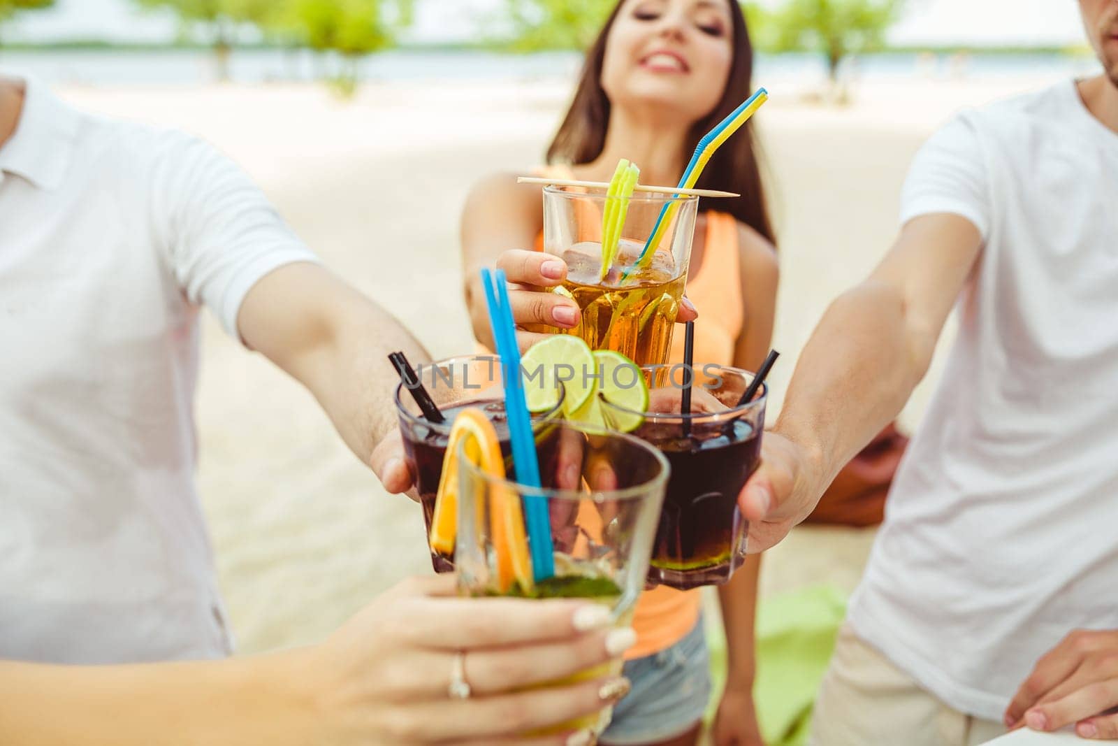 Friends having fun at the bar outdoors, drinking cocktails. by nazarovsergey