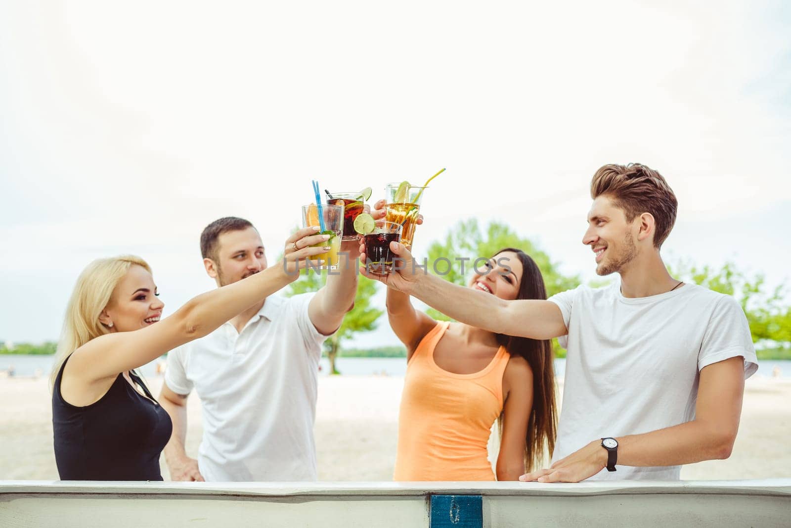 Friends having fun at the bar outdoors, drinking cocktails. Summer bar