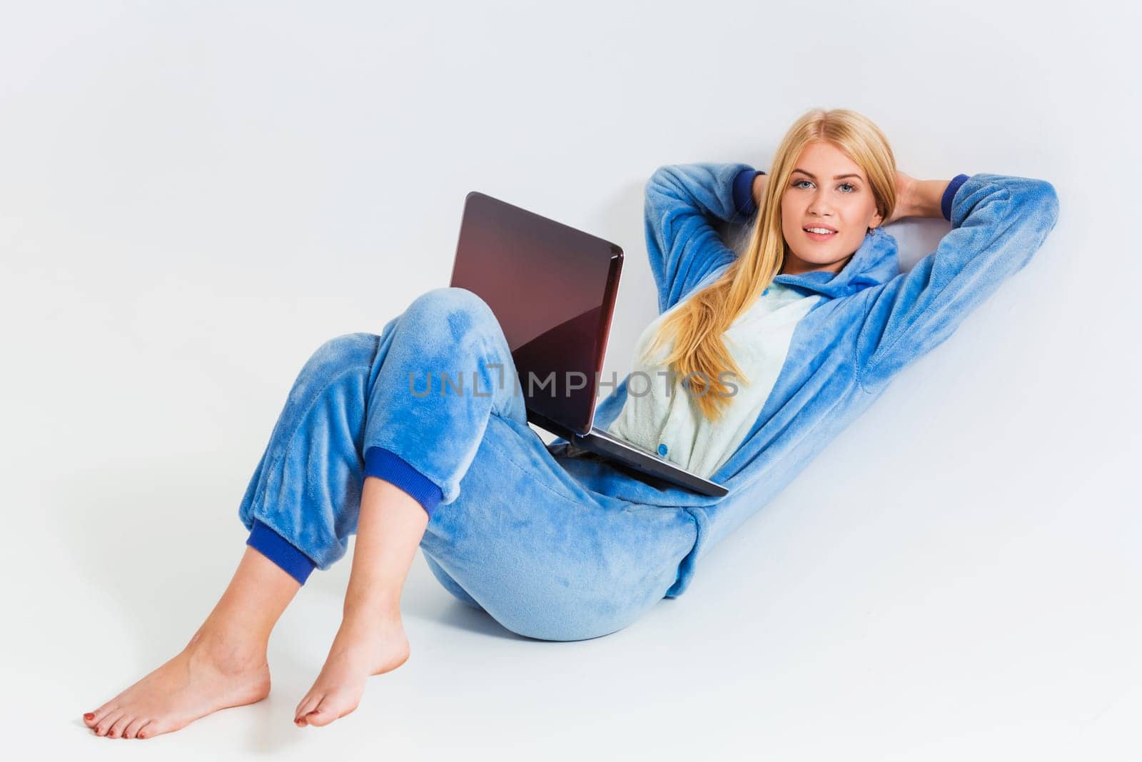 girl in pajamas with a laptop lying on the floor by nazarovsergey