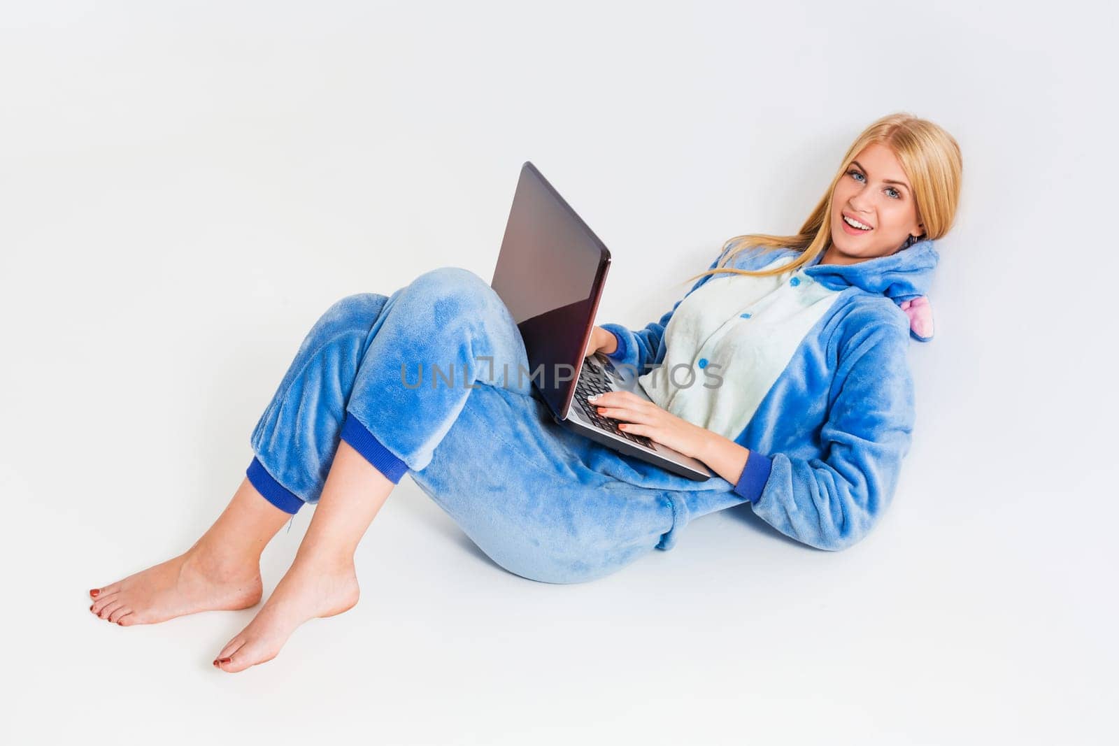 girl in pajamas with a laptop lying on the floor by nazarovsergey