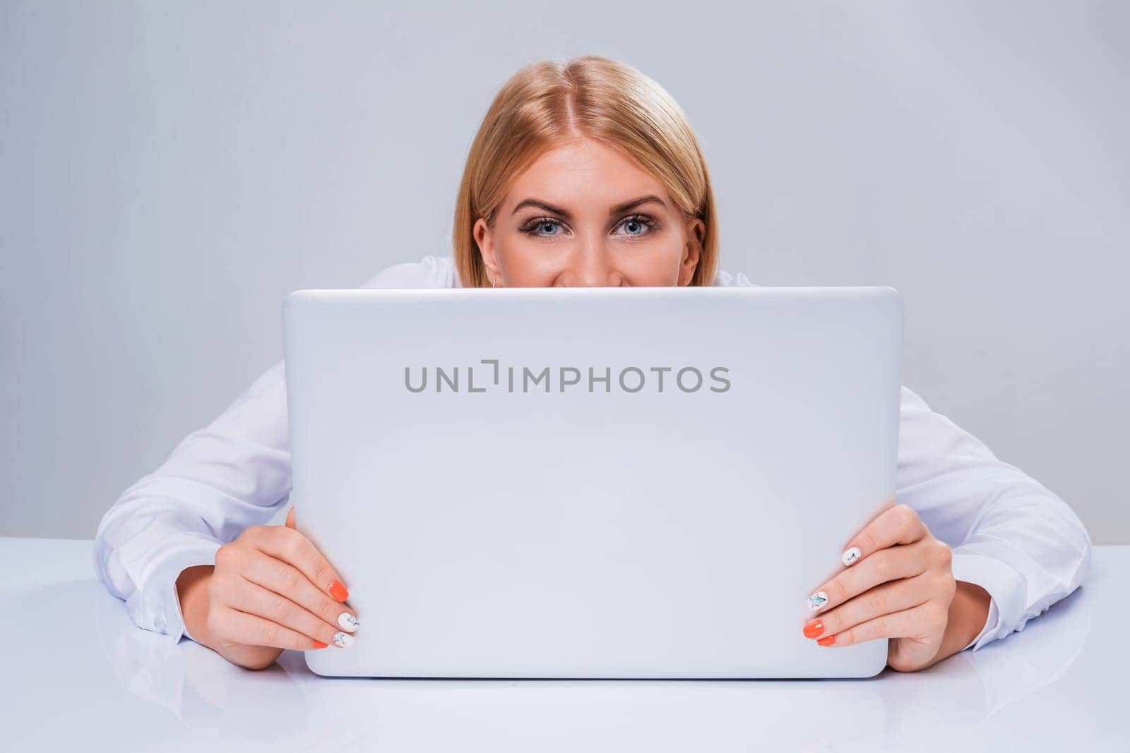 Young businesswoman working at laptop computer. hiding behind the monitor