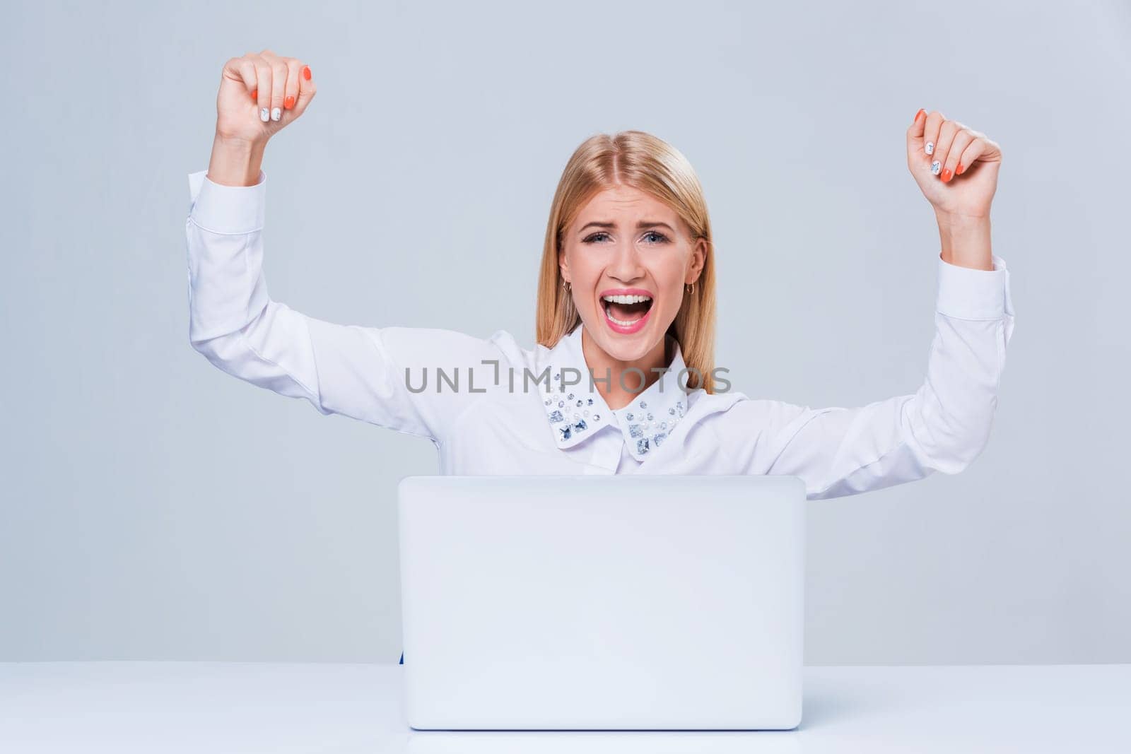 Young businesswoman working at laptop computer. hiding behind the monitor contented happy girl