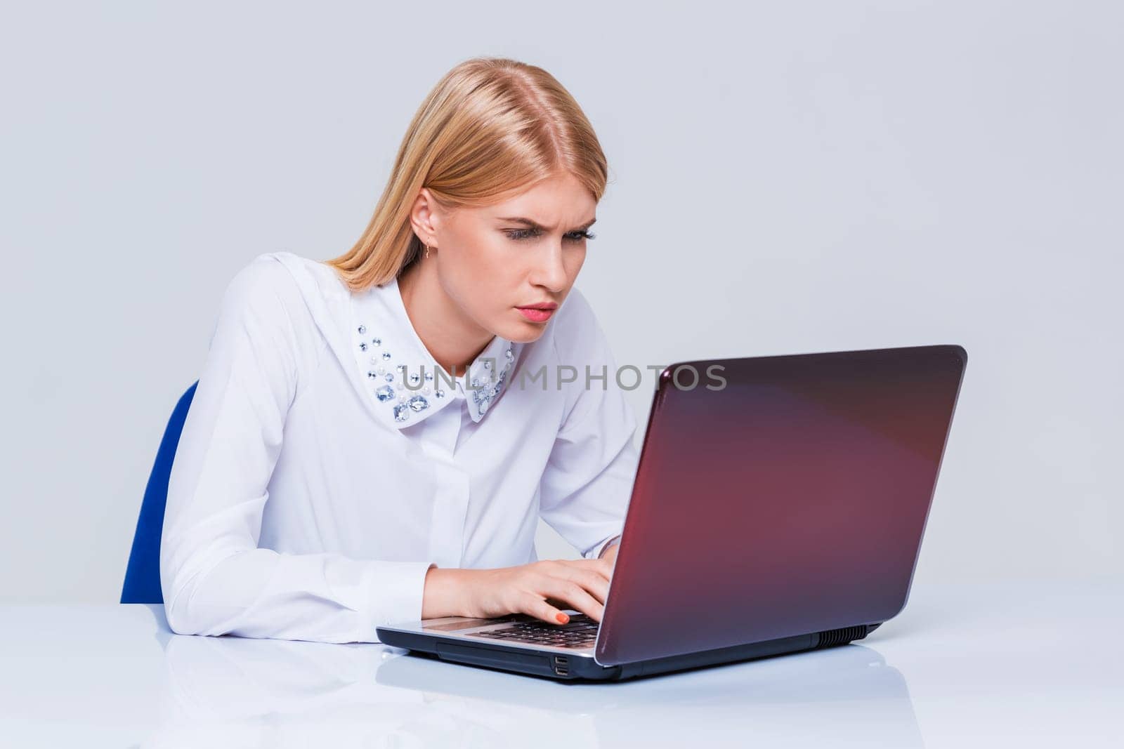 Young businesswoman working at laptop computer. pleasantly surprised dissatisfied girl