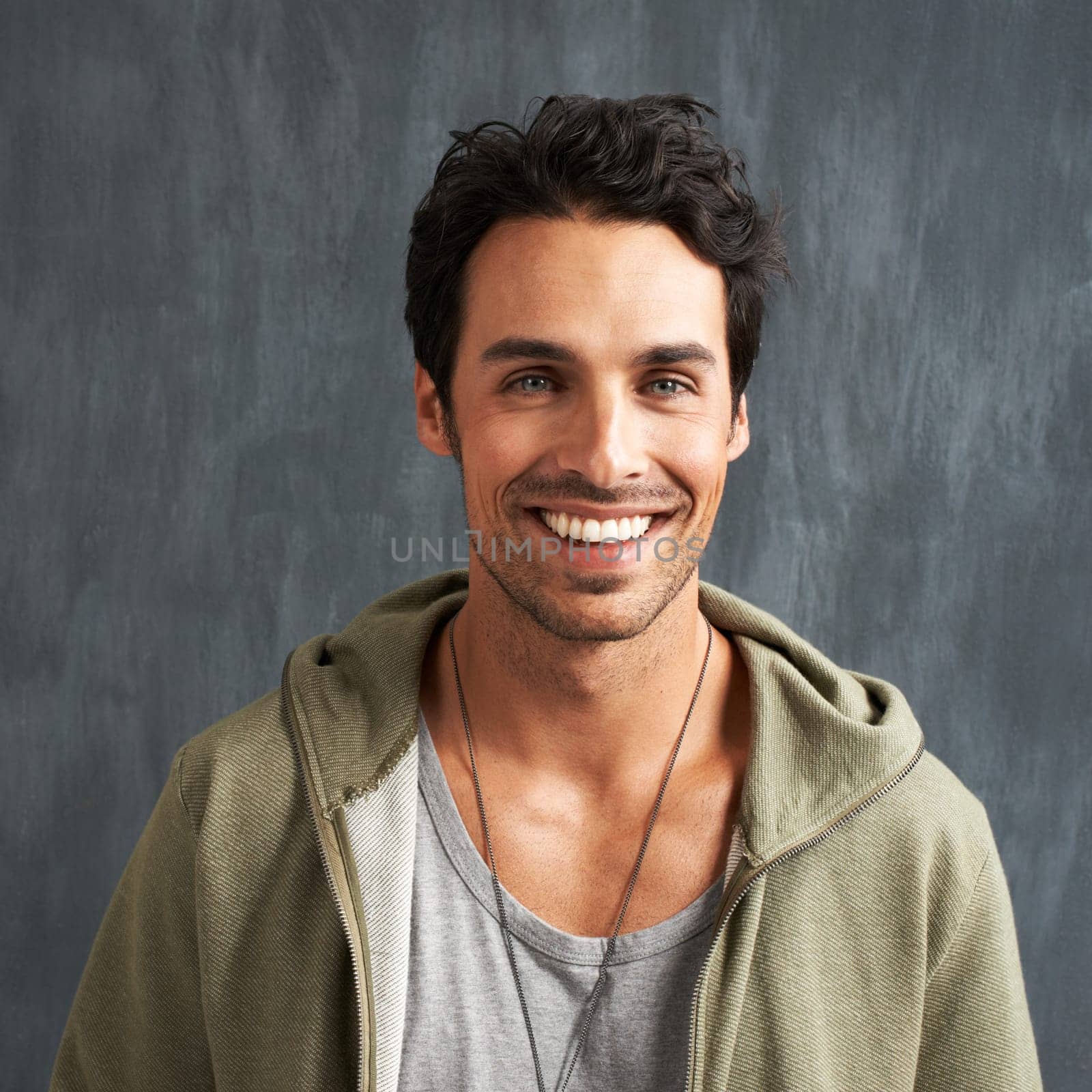 Fashion, happy and portrait of man on gray background with trendy style, clothes and casual outfit. Smile, handsome and face of person on texture wall with confidence, pride and positive attitude.