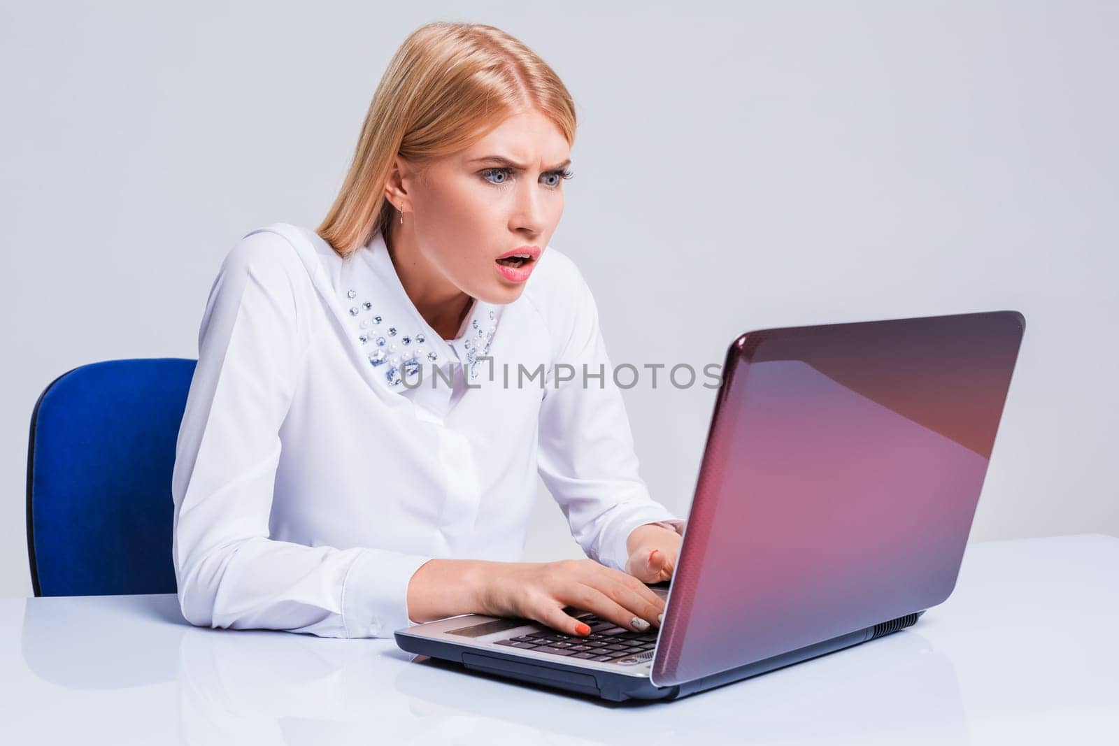 Young businesswoman working at laptop computer. pleasantly surprised dissatisfied girl