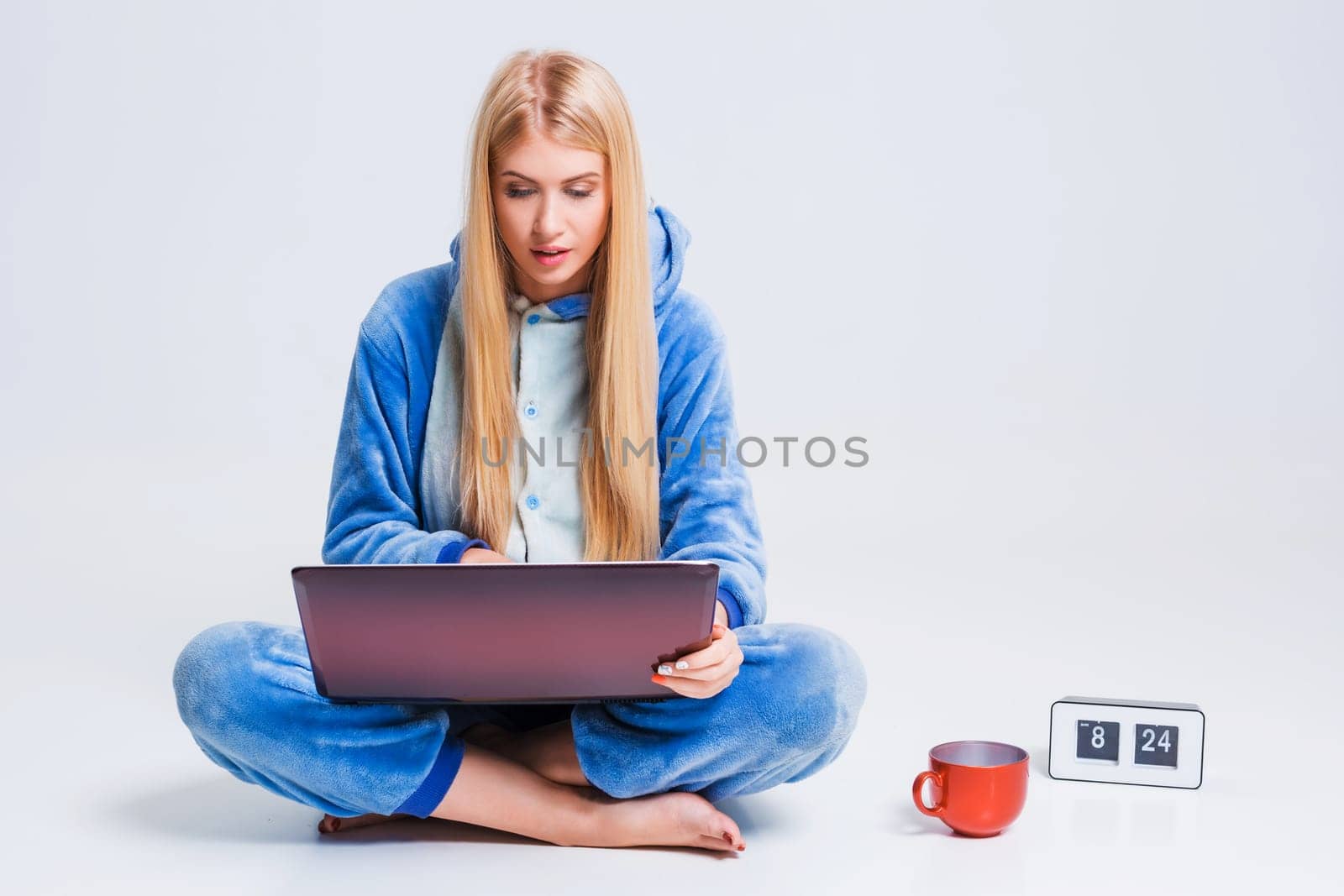 girl in pajamas with a laptop lying on the floor. studying or doing online shopping. work from home. Satisfied and smiling in the morning