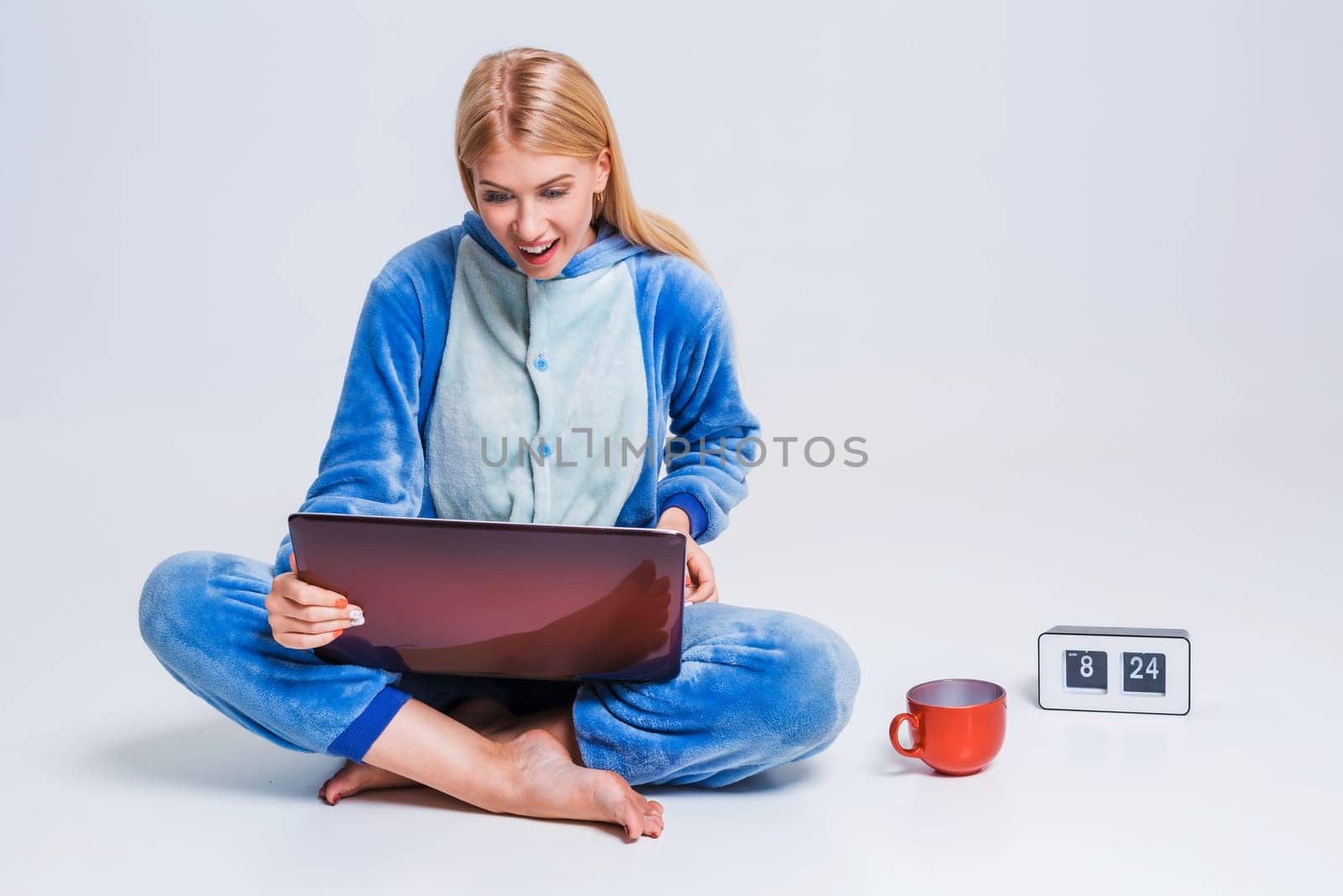 girl in pajamas with a laptop lying on the floor. studying or doing online shopping. work from home. Satisfied and smiling in the morning