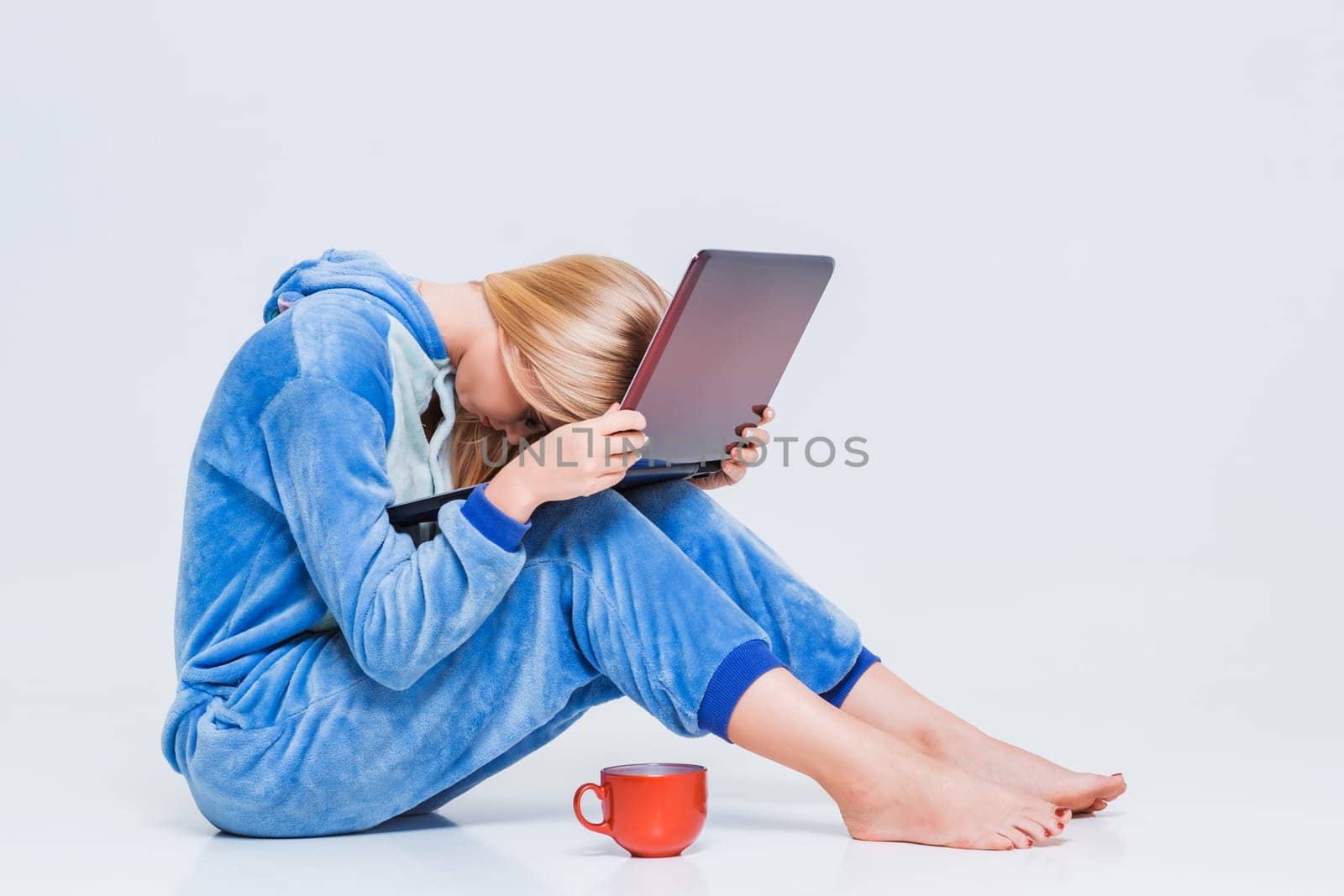 girl in pajamas with a laptop lying on the floor. studying or doing online shopping. work from home. tired woman, it does not work