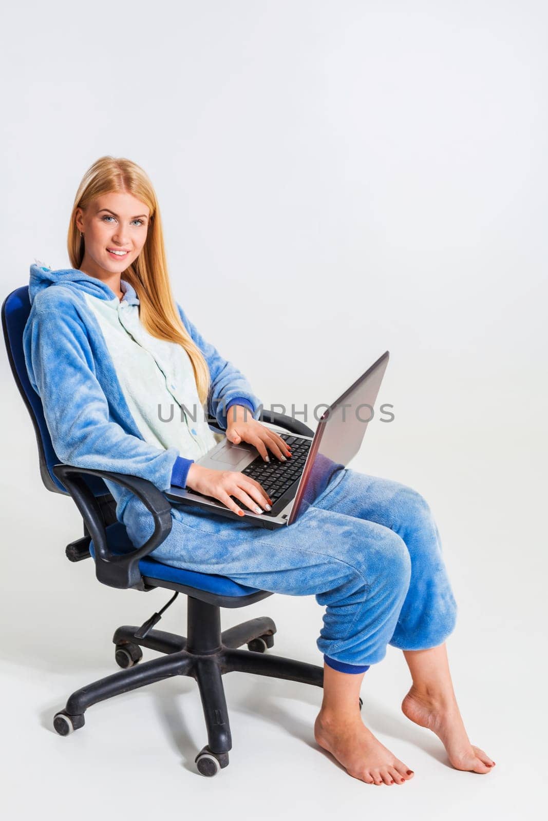 girl in pajamas with a laptop. studying or doing online shopping. work from home. girl smiling and happy