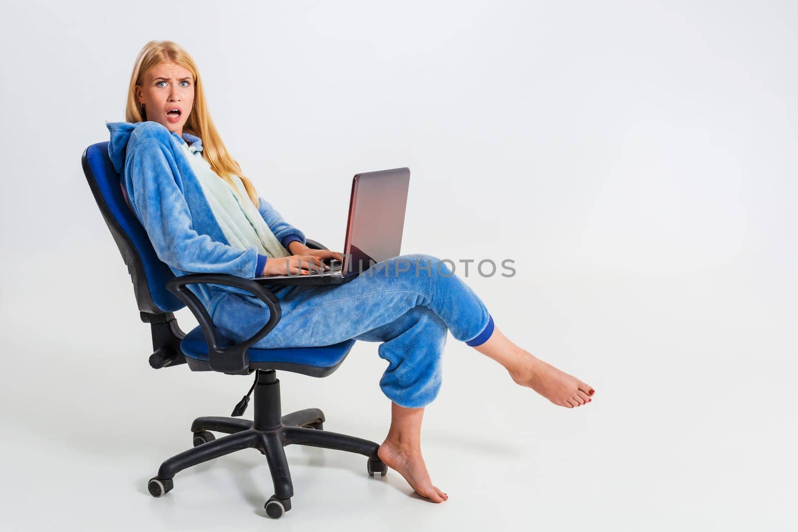 girl in pajamas with a laptop. studying or doing online shopping. work from home. girl smiling and happy