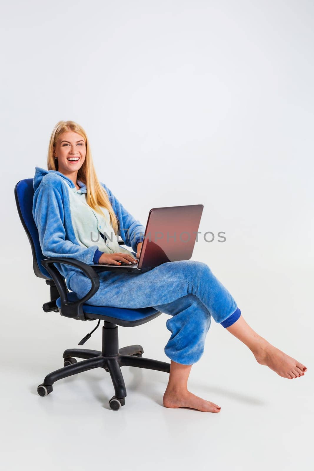 girl in pajamas with a laptop. studying or doing online shopping. work from home. girl smiling and happy