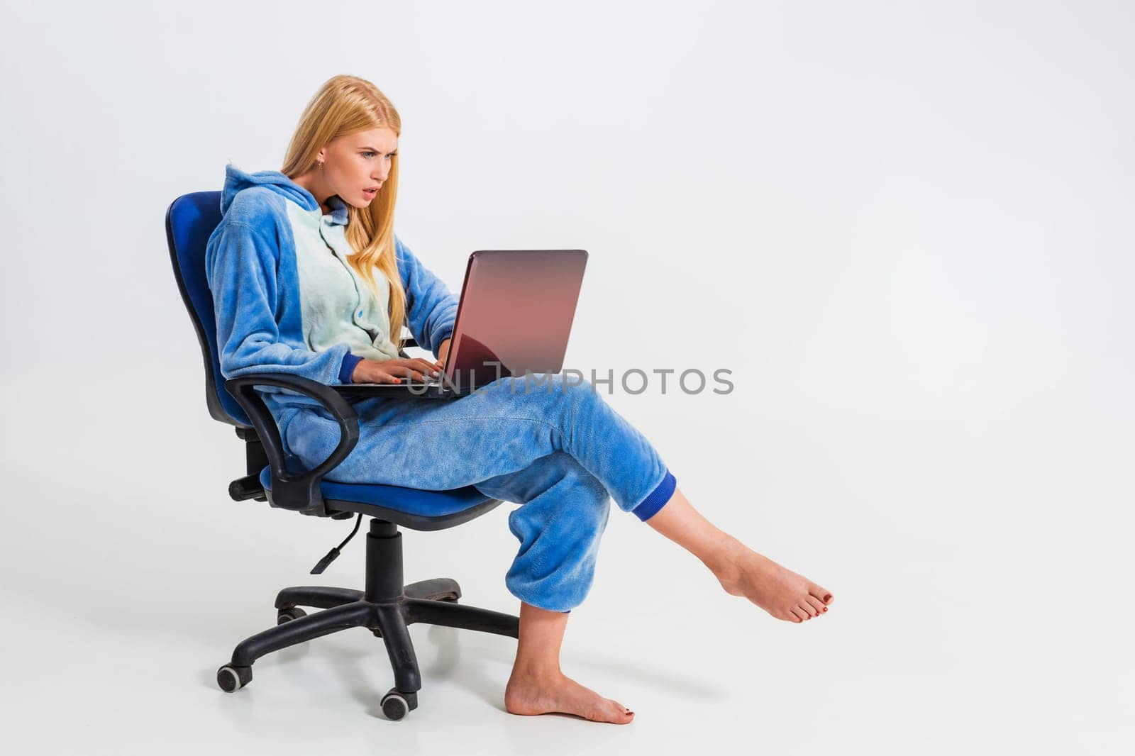 girl in pajamas with a laptop. studying or doing online shopping. work from home. tired girl