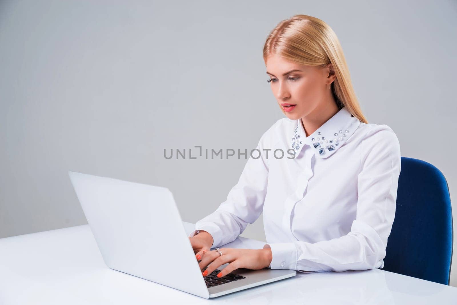 Young businesswoman working at laptop computer. she sits smiling