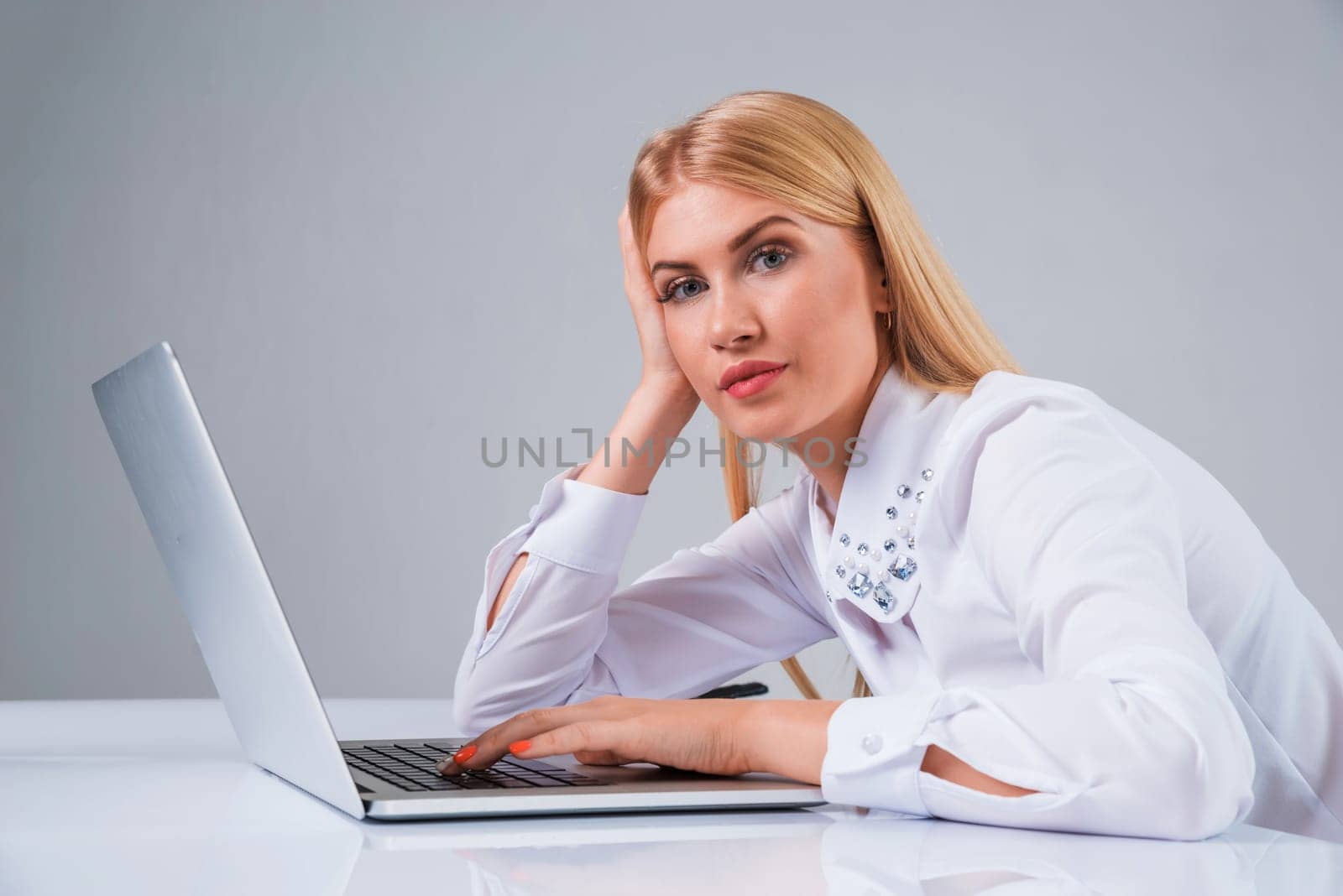 Young businesswoman working at laptop computer. tired, hunched, pleased