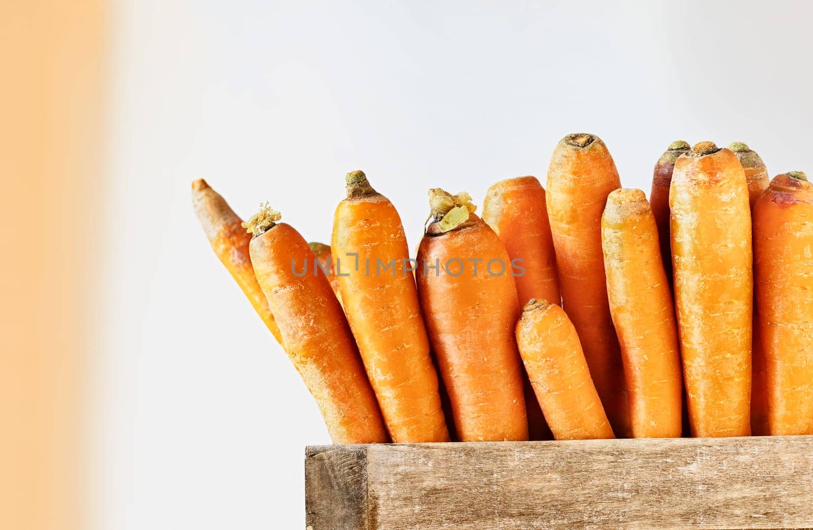 Bunch of orange carrots in wooden box on wooden table ,