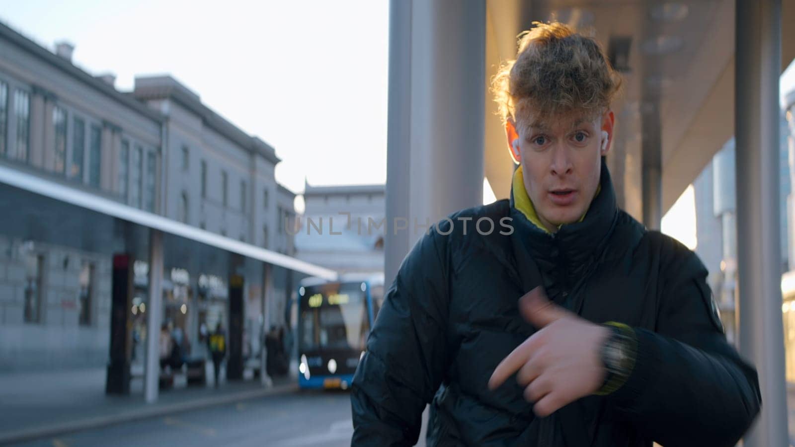 Young man dancing in modern style on street. Action. Man is dancing modern cool dance. Young man in jacket dancing on sunny day on street.