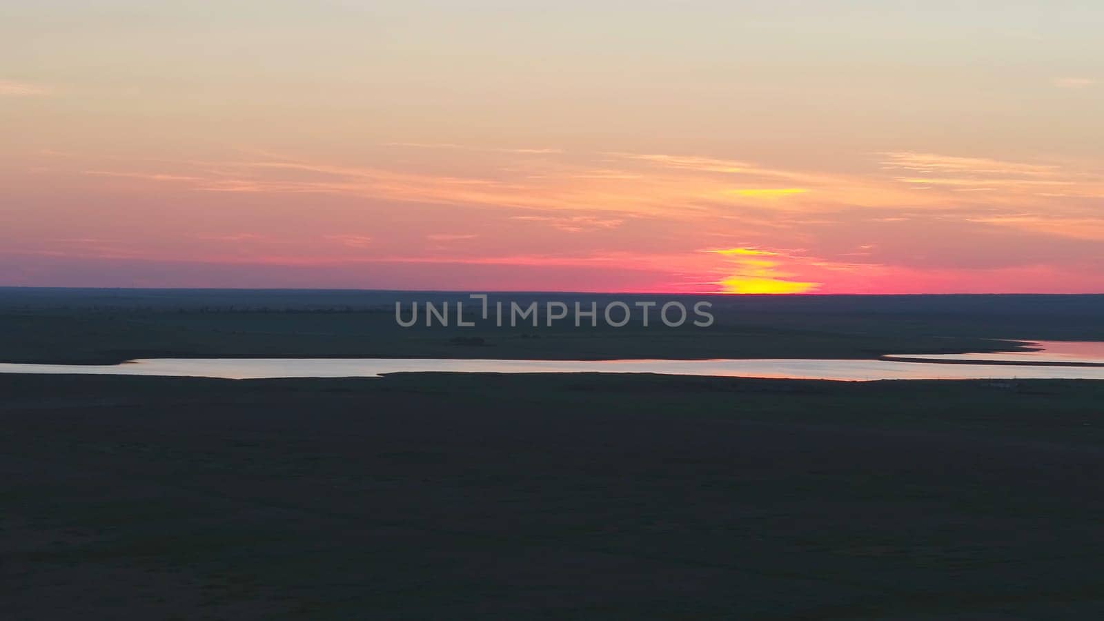 Aerial view of beautiful emerald green water lake and summer landscape sunset. Sunset on the lake.