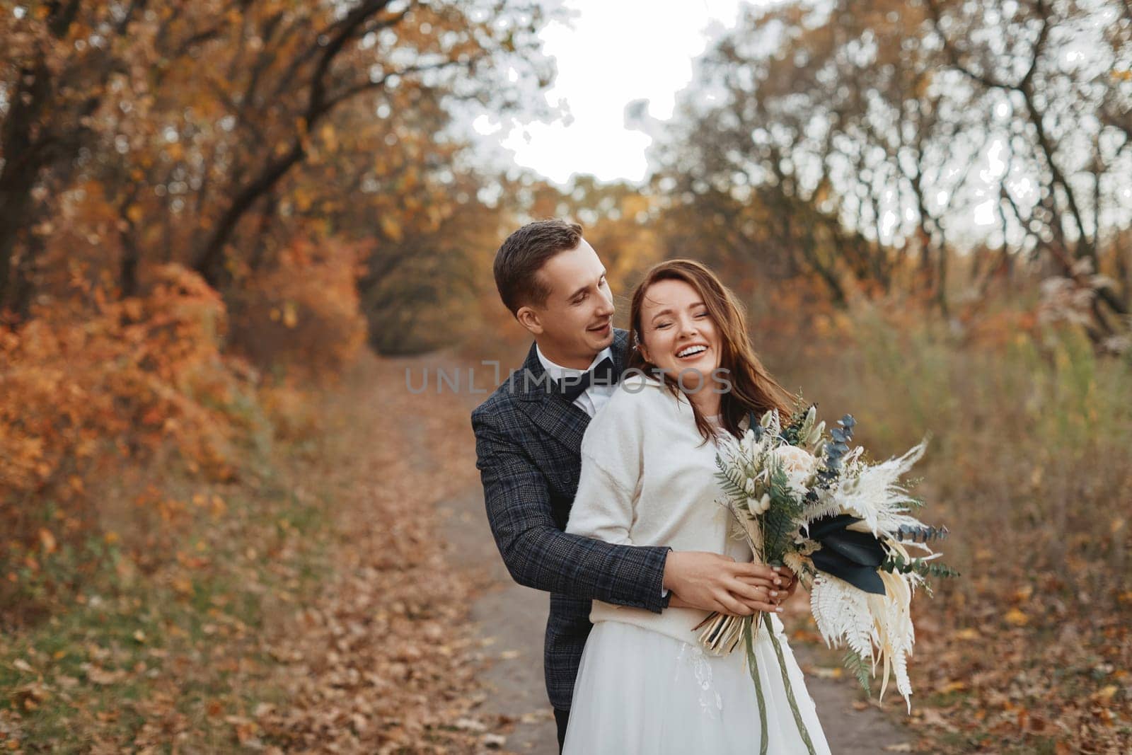 happy bride and groom enjoying romantic moments outside in autumn