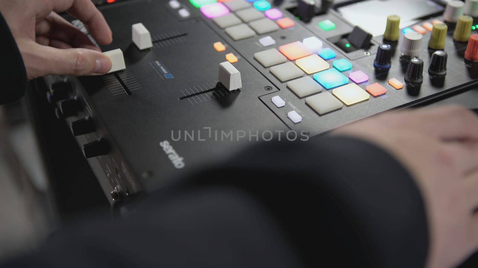 Click colored squares on mixer panel. ART. Hands in dark room are dialing code from multi-colored squares. Abstract music on mixer color board.