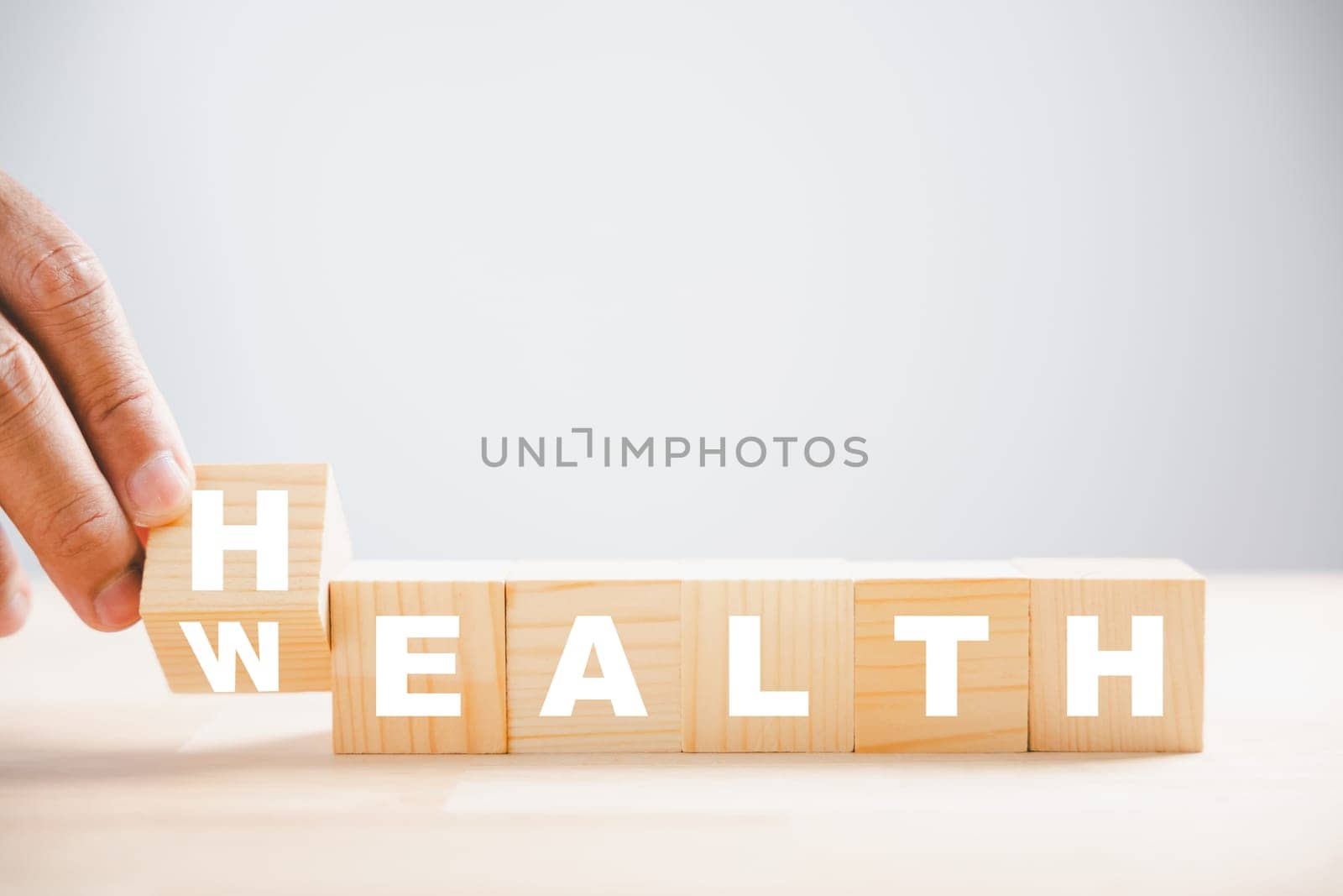 Wooden cube flip Wealth to Health. Table setup with health and wealth symbols. Life insurance and medical concept. Wellness healthcare